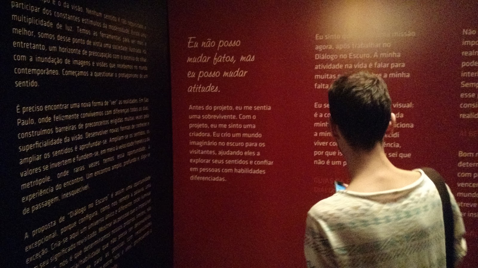 Visitante em São Paulo lendo a parede com frases da Exposição. Entre elas, "Eu não posso mudar fatos, mas eu posso mudar atitudes."